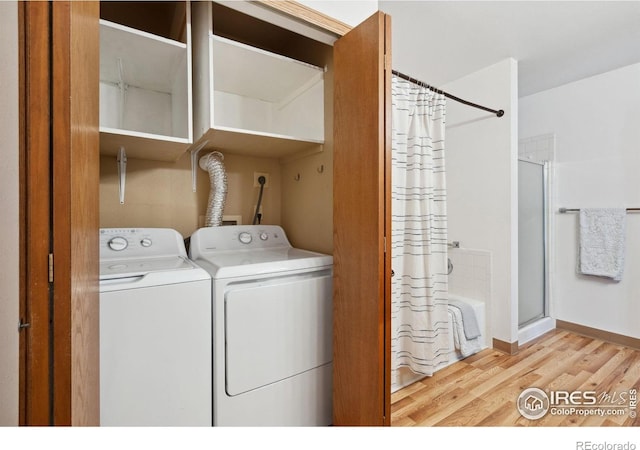 4560 Larkbunting Dr Unit 2B, Fort Collins, CO 80526 - washroom with washer and clothes dryer, light wood-type flooring, and baseboards