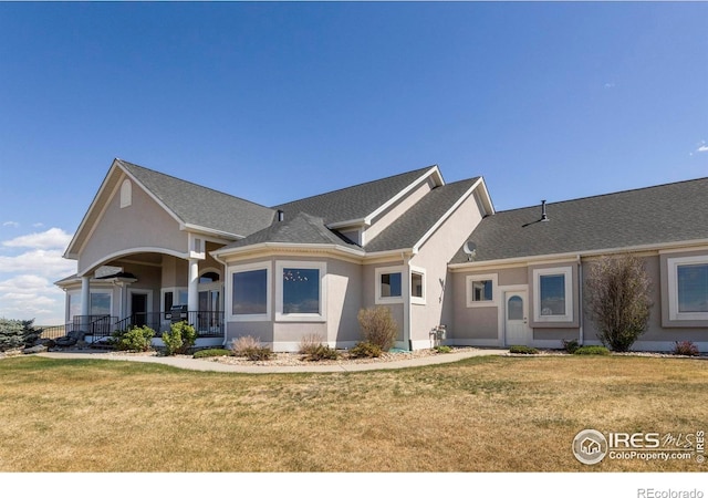 craftsman-style house with stucco siding, a porch, and a front lawn
