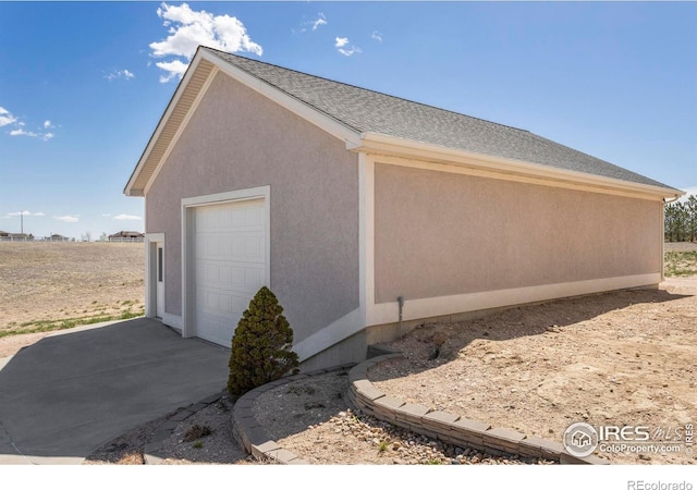 view of side of property featuring driveway and stucco siding