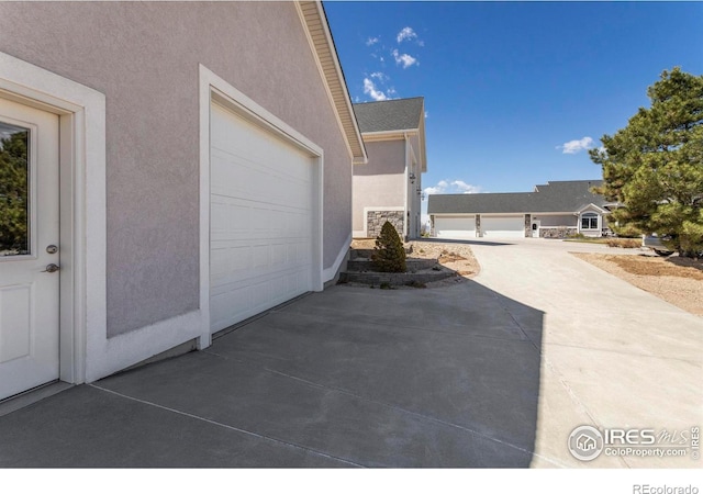 view of patio / terrace with driveway and a garage