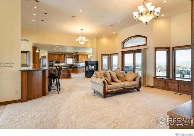 living room featuring recessed lighting, a high ceiling, an inviting chandelier, and light carpet