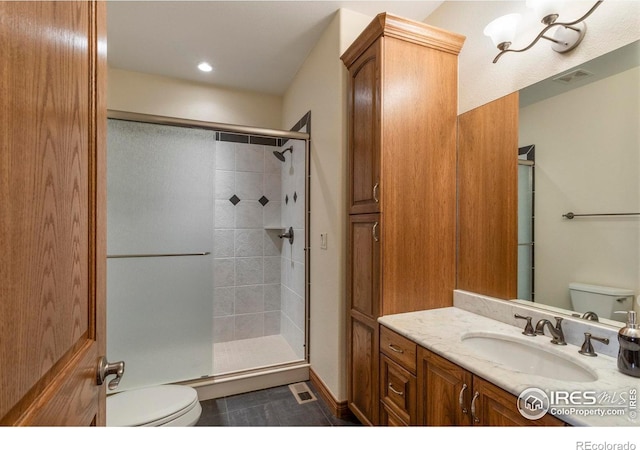 full bathroom with toilet, visible vents, tiled shower, and vanity