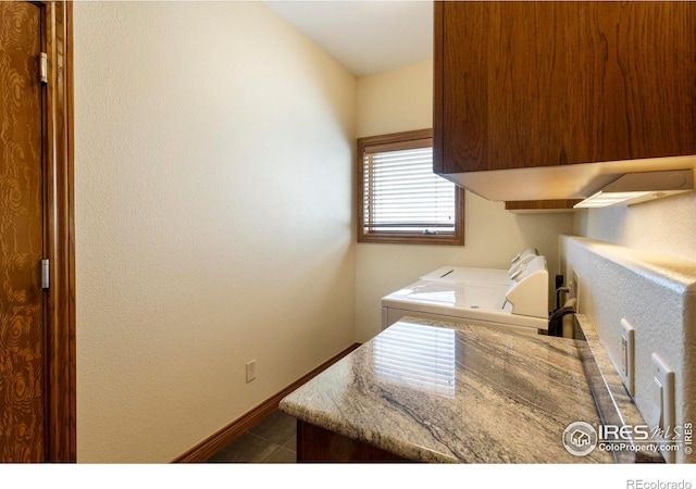 laundry area featuring baseboards, cabinet space, and washing machine and dryer