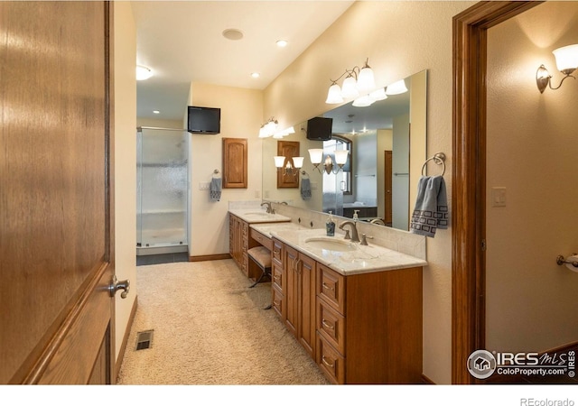 bathroom with visible vents, a sink, a shower with door, and double vanity