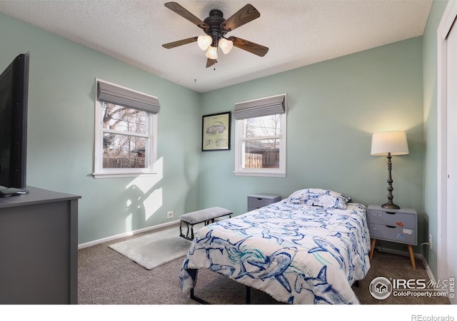 carpeted bedroom featuring a textured ceiling, baseboards, and a ceiling fan