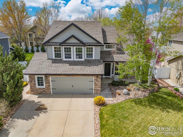 109 Whitney Ct, Windsor, CO 80550 - view of front of home with concrete driveway, a shingled roof, an attached garage, and stone siding