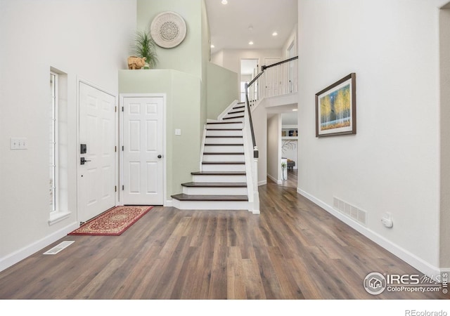 109 Whitney Ct, Windsor, CO 80550 - foyer entrance featuring a towering ceiling, baseboards, wood finished floors, stairs, and recessed lighting