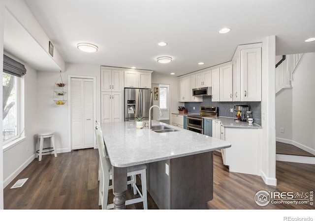 109 Whitney Ct, Windsor, CO 80550 - kitchen with stainless steel appliances, a sink, baseboards, dark wood-type flooring, and recessed lighting