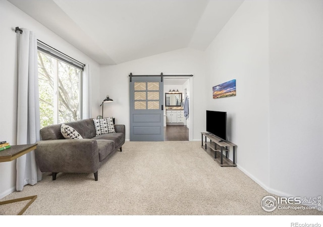 109 Whitney Ct, Windsor, CO 80550 - living area with vaulted ceiling, carpet, a barn door, and baseboards