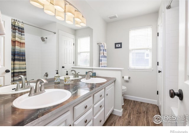 109 Whitney Ct, Windsor, CO 80550 - bathroom featuring double vanity, toilet, wood finished floors, a shower with curtain, and baseboards
