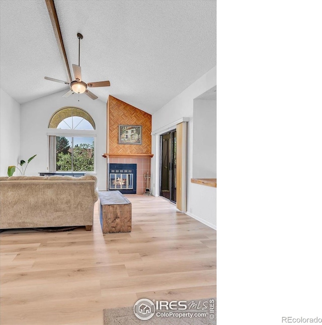 5035 W 73rd Ave, Westminster, CO 80030 - living area featuring a ceiling fan, vaulted ceiling, a textured ceiling, wood finished floors, and a fireplace