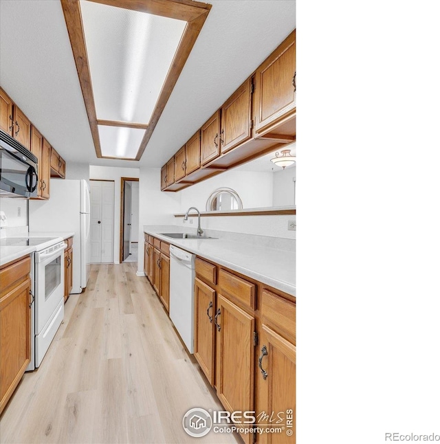 5035 W 73rd Ave, Westminster, CO 80030 - kitchen featuring a sink, white appliances, light countertops, and light wood-type flooring