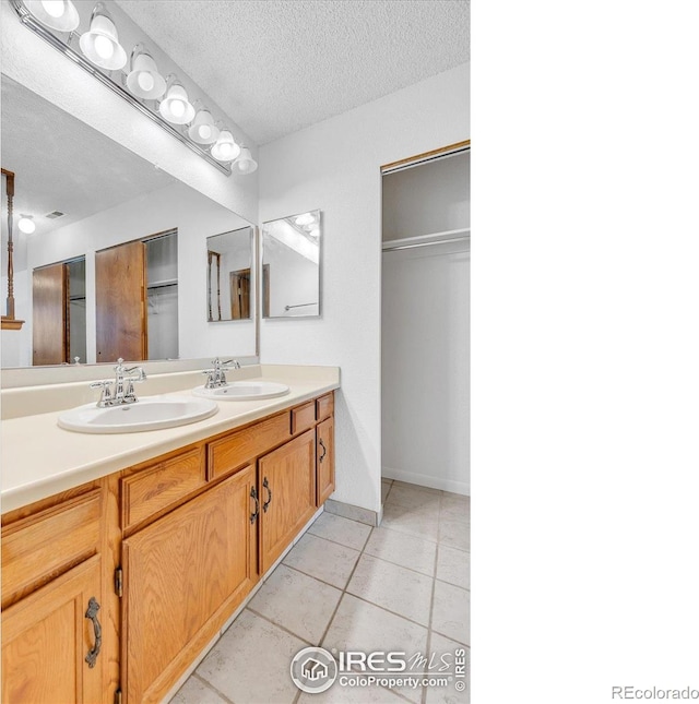 5035 W 73rd Ave, Westminster, CO 80030 - full bathroom featuring a sink, double vanity, a textured ceiling, and tile patterned floors