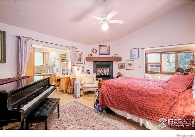 1800 Sumac Ave, Boulder, CO 80304 - bedroom featuring a glass covered fireplace, multiple windows, wood finished floors, and vaulted ceiling