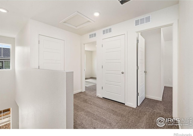 corridor with visible vents and carpet floors