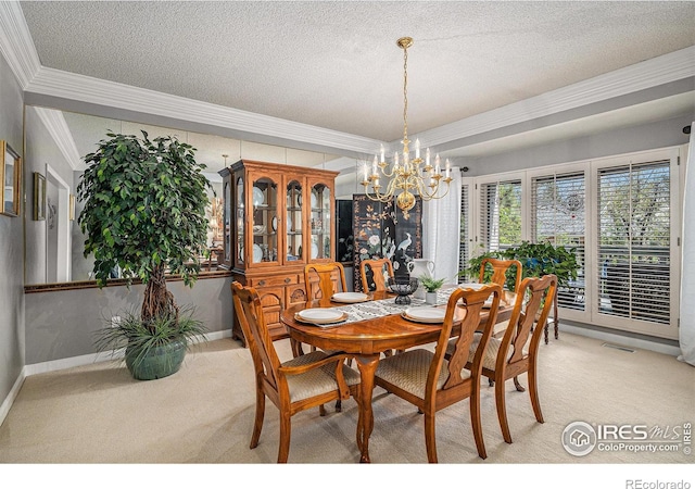 dining space with a textured ceiling, an inviting chandelier, ornamental molding, and light carpet