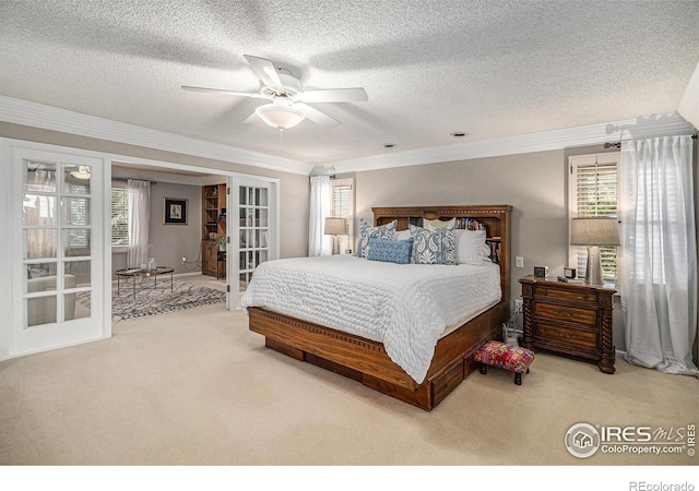 carpeted bedroom featuring ornamental molding, a ceiling fan, french doors, and a textured ceiling