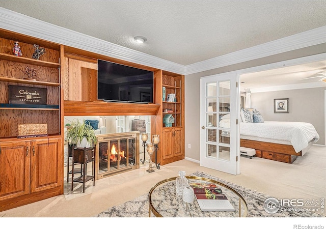 bedroom featuring ornamental molding, baseboards, french doors, a fireplace with flush hearth, and carpet