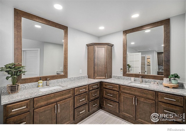 bathroom with a sink, recessed lighting, and double vanity
