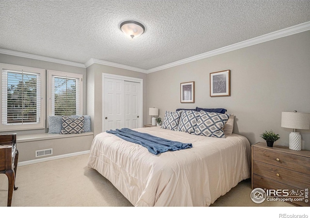 bedroom with crown molding, carpet floors, a textured ceiling, visible vents, and a closet