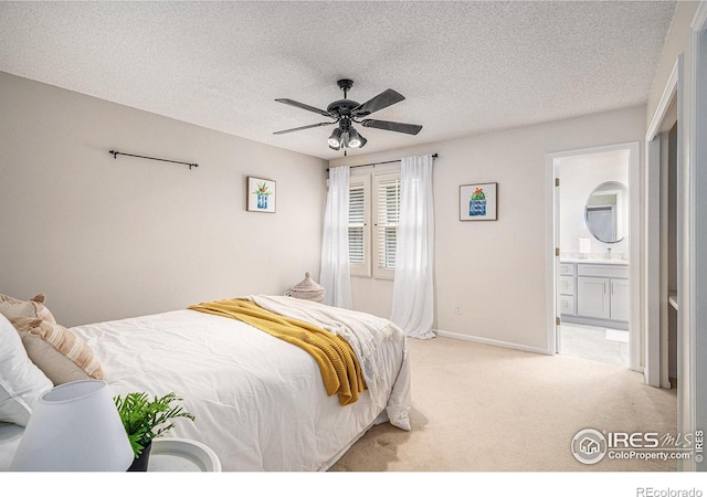 bedroom featuring light carpet, ensuite bath, a textured ceiling, a ceiling fan, and baseboards