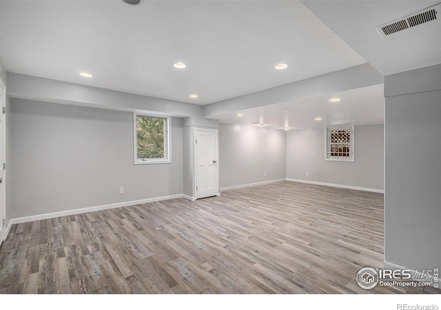 below grade area featuring recessed lighting, baseboards, visible vents, and wood finished floors