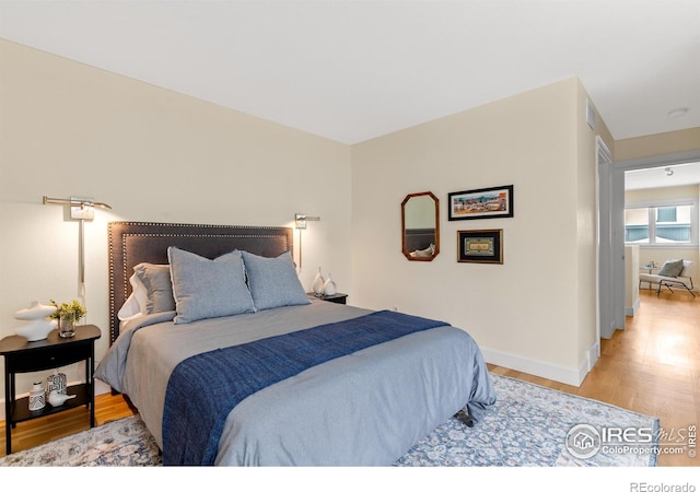 bedroom featuring light wood-style floors and baseboards