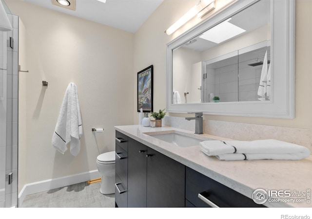 bathroom with toilet, baseboards, a shower with shower door, and vanity