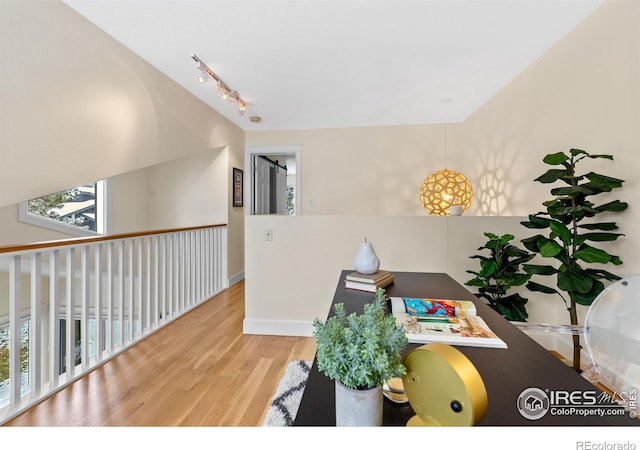 home office with track lighting, baseboards, and wood finished floors