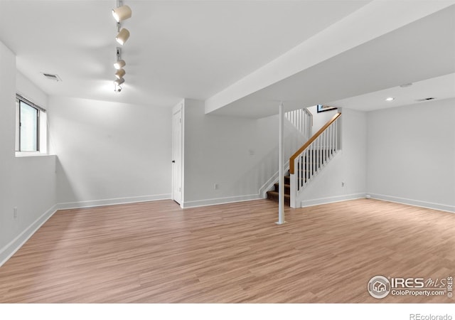 unfurnished living room featuring stairway, baseboards, light wood-type flooring, and visible vents