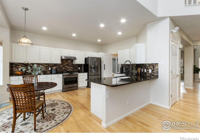 kitchen featuring decorative backsplash, electric range, light wood finished floors, refrigerator with ice dispenser, and under cabinet range hood