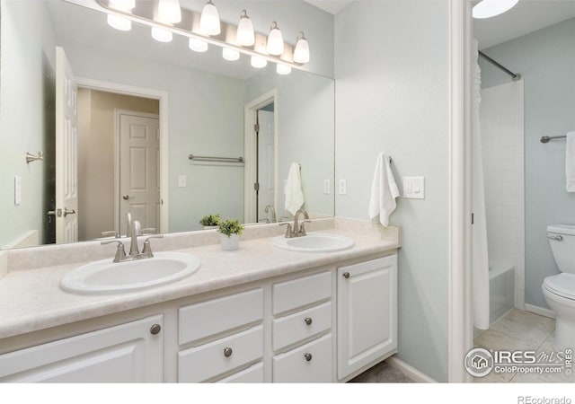 full bathroom featuring a sink, tile patterned flooring, toilet, and double vanity