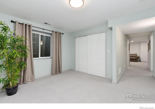 unfurnished bedroom with visible vents, carpet, baseboards, and a closet