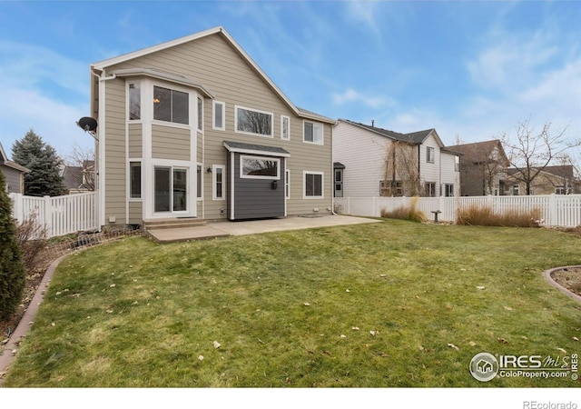 back of house with a fenced backyard, a lawn, and a patio area