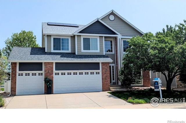116 Rock Bridge Ct, Windsor, CO 80550 - view of front of property with concrete driveway, roof mounted solar panels, brick siding, roof with shingles, and an attached garage