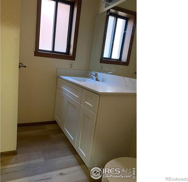1961 Centennial Dr, Louisville, CO 80027 - bathroom featuring baseboards, vanity, toilet, and wood finished floors