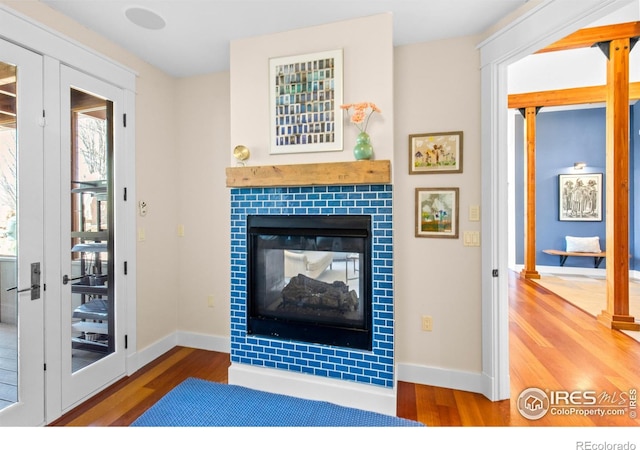 1533 Old Tale Rd, Boulder, CO 80303 - living area with baseboards, wood finished floors, a fireplace, and french doors