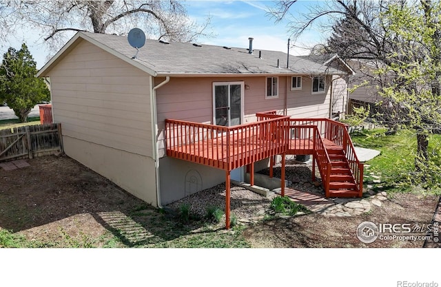 back of house featuring a shingled roof, stairway, fence, and a deck