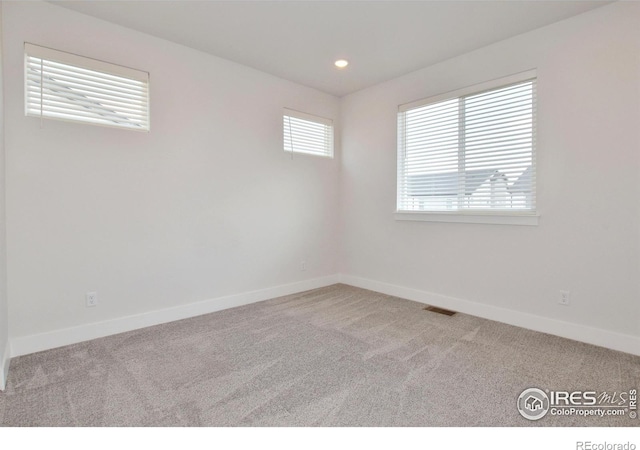 carpeted spare room featuring baseboards and recessed lighting