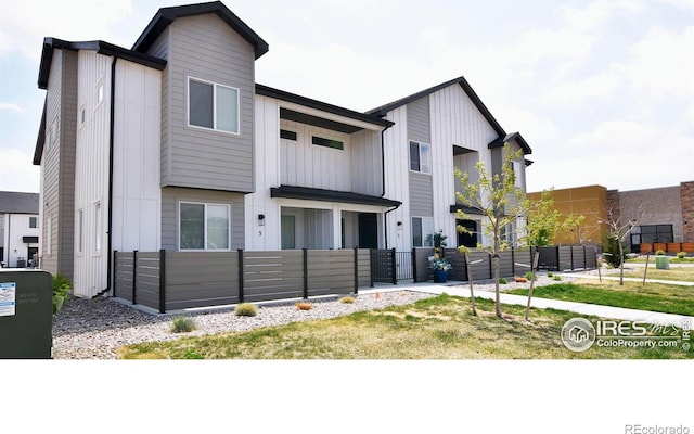 view of front of property featuring a fenced front yard, board and batten siding, and a gate