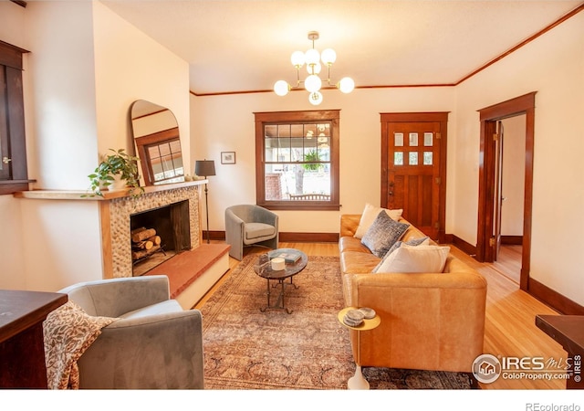 1114 5th Ave, Longmont, CO 80501 - living room featuring baseboards, a fireplace, wood finished floors, and a chandelier
