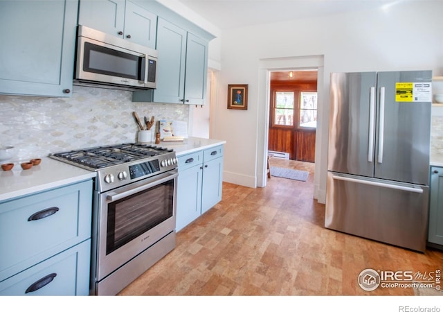 1114 5th Ave, Longmont, CO 80501 - kitchen with appliances with stainless steel finishes, tasteful backsplash, light countertops, baseboards, and a baseboard radiator