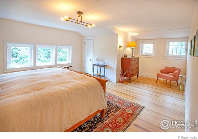 1114 5th Ave, Longmont, CO 80501 - bedroom featuring baseboards, wood finished floors, and a notable chandelier