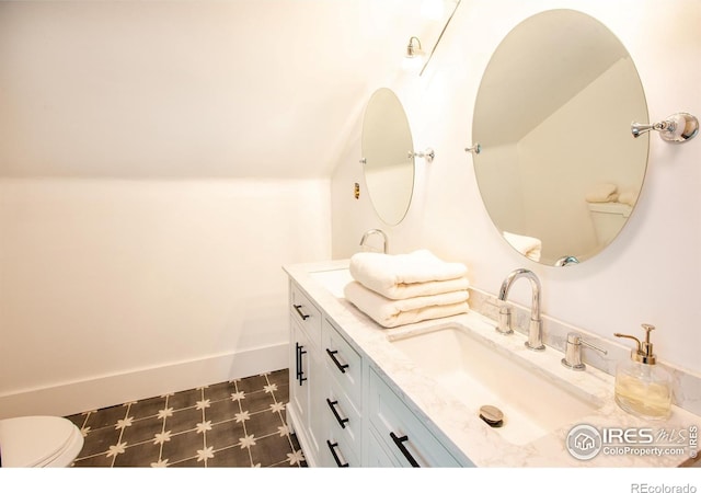 1114 5th Ave, Longmont, CO 80501 - bathroom with toilet, tile patterned floors, lofted ceiling, and vanity