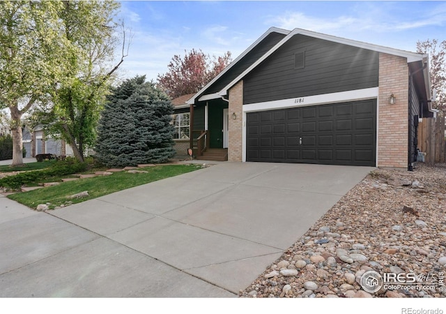 view of front of home with a garage, concrete driveway, and brick siding