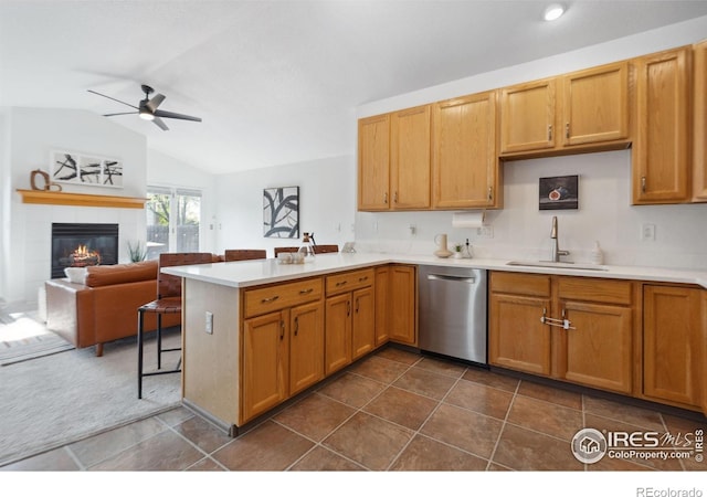 kitchen featuring a sink, a ceiling fan, a peninsula, lofted ceiling, and stainless steel dishwasher