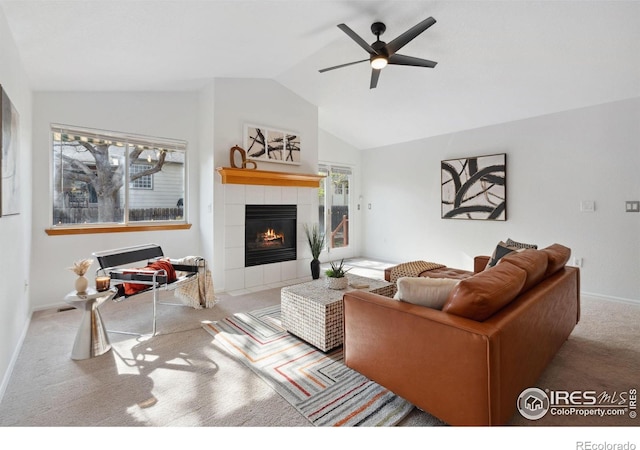 living area with a ceiling fan, a fireplace, vaulted ceiling, baseboards, and carpet flooring
