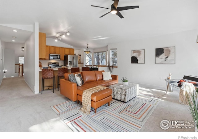 living area with a ceiling fan, light colored carpet, vaulted ceiling, track lighting, and baseboards