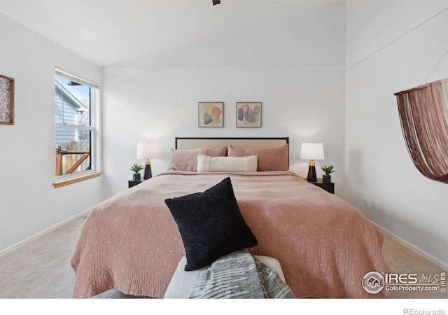 bedroom with carpet floors, baseboards, and lofted ceiling