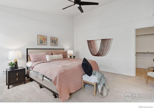 carpeted bedroom with baseboards, a spacious closet, ceiling fan, and lofted ceiling